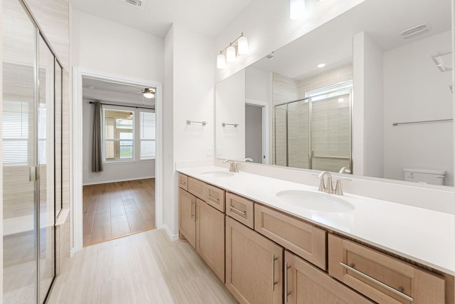 Double vanities and an ample shower offer a spacious, well-appointed primary bathroom. Double vanities and an ample shower offer a spacious, well-appointed primary bathroom.