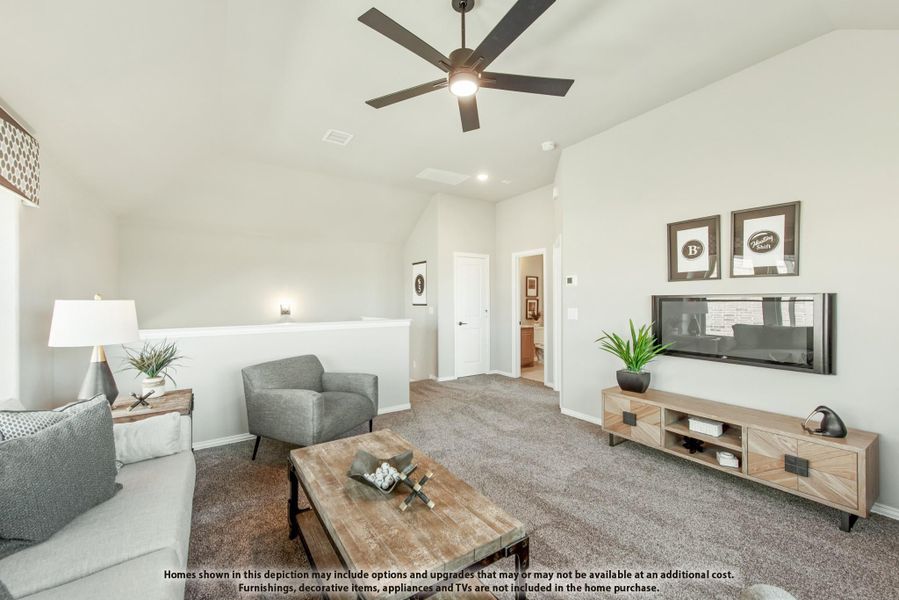 Upstairs living area with vaulted ceiling, ceiling fan, carpet flooring, and wall-mounted TV on wood media console