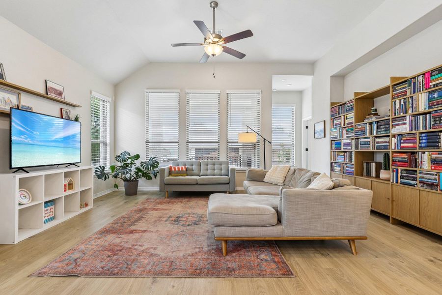 A vibrant living space featuring high ceilings, hardwood flooring, and ample natural light.