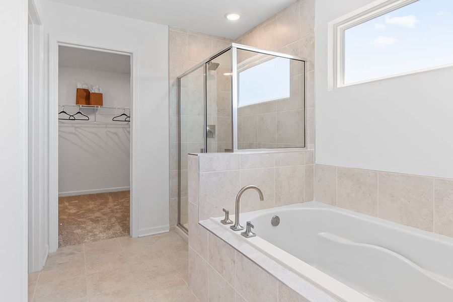 A bathroom with a tub and a mirror.