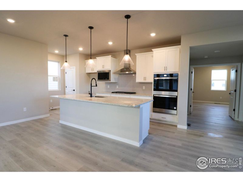 Flooded in natural light, this kitchen has soft close cabinetry, a 36" vent hood, a 36" gas cooktop, double ovens, undercount sink and a built-in microwave.