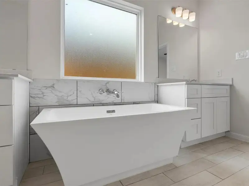 A deep soaking tub awaits in this newly refreshed bathroom, promising relaxation.