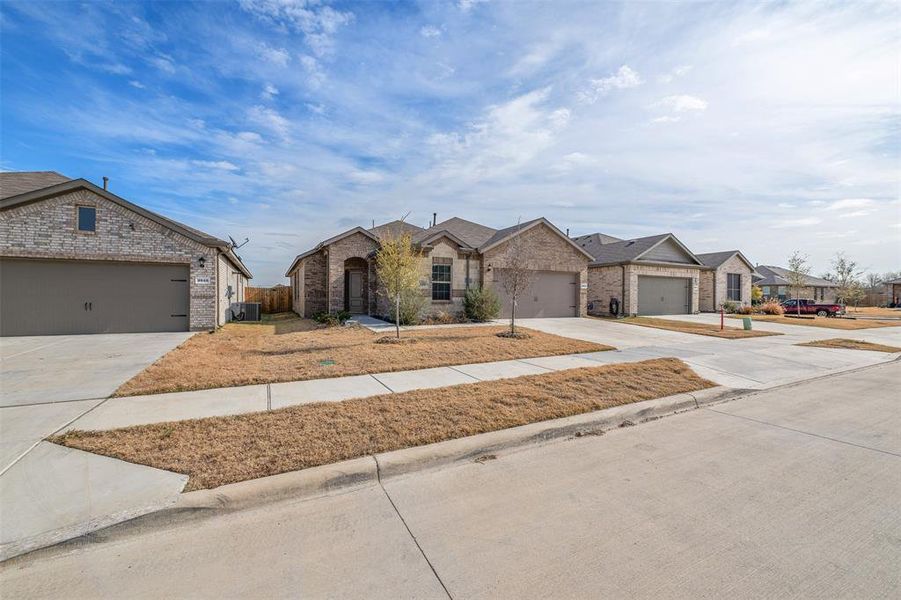 Single story home with a garage and central AC unit