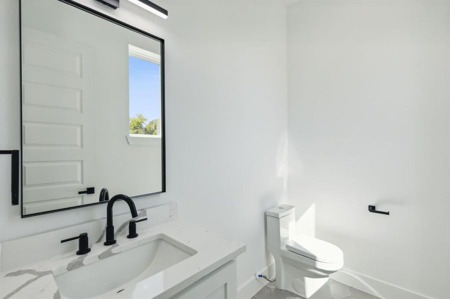 Powder bath featuring toilet and vanity