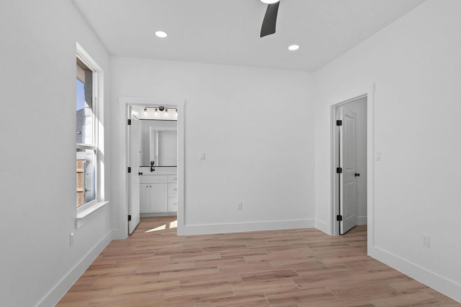 Unfurnished bedroom featuring light wood-style flooring, ensuite bathroom, a ceiling fan, and recessed lighting Unfurnished bedroom featuring light wood-style flooring, ensuite bathroom, a ceiling fan, and recessed lighting