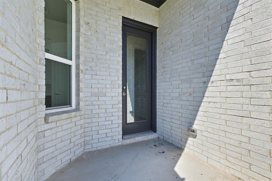Doorway to property featuring a patio and brick siding Doorway to property featuring a patio and brick siding