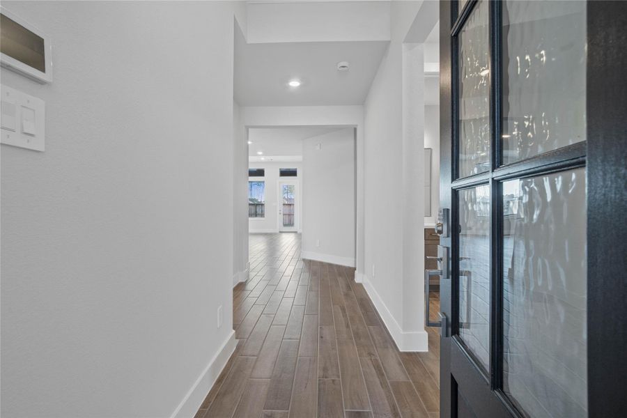 Welcome inside to a bright and inviting entryway that sets the tone for this modern home. Crisp white walls and abundant natural light create an open and spacious feel throughout the hallway. The tile plank flooring extends seamlessly through the area, offering both aesthetic appeal and durability. Welcome inside to a bright and inviting entryway that sets the tone for this modern home. Crisp white walls and abundant natural light create an open and spacious feel throughout the hallway. The tile plank flooring extends seamlessly through the area, offering both aesthetic appeal and durability.