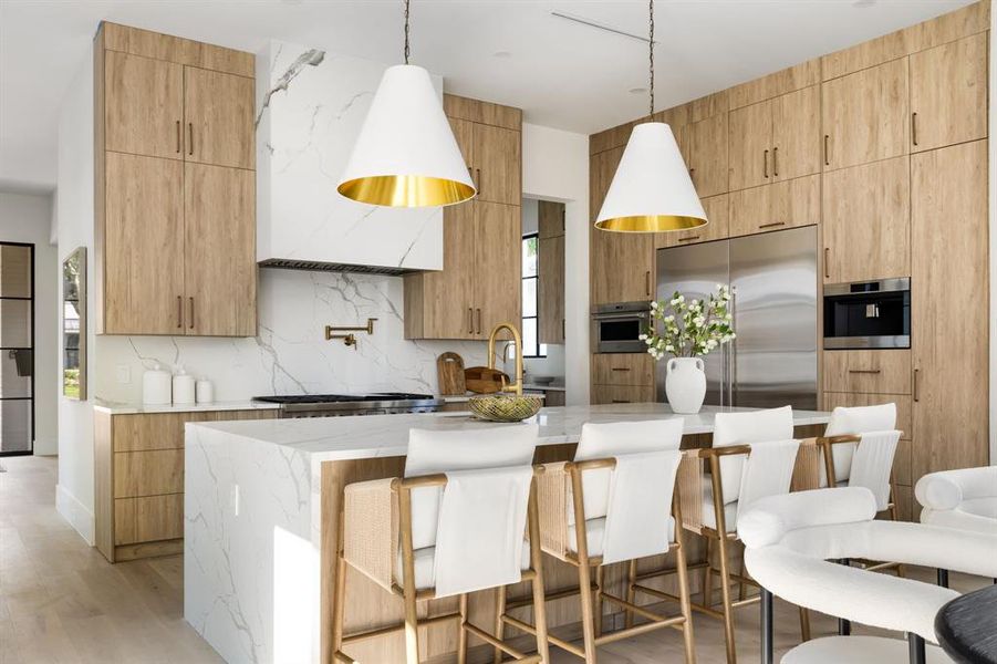 Kitchen featuring modern cabinets, light stone countertops, and light brown cabinetry Kitchen featuring modern cabinets, light stone countertops, and light brown cabinetry