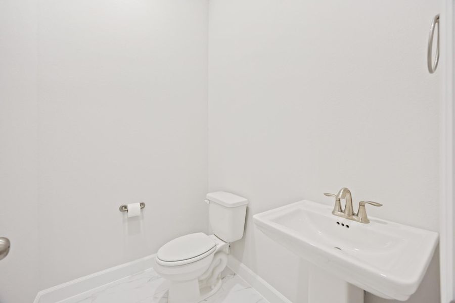 A downstairs retreat featuring a timeless pedestal sink, offering both style and convenience. A downstairs retreat featuring a timeless pedestal sink, offering both style and convenience.