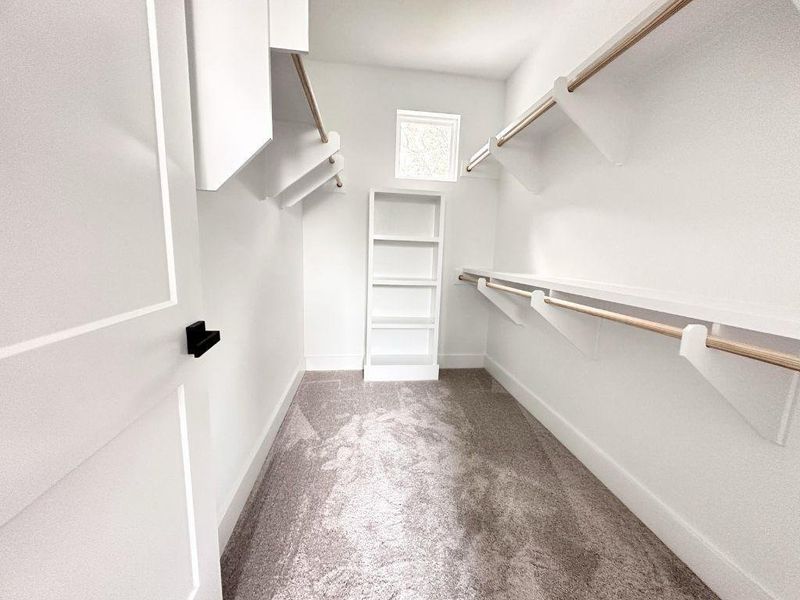 Ample storage solutions define this well-appointed walk-in closet, complete with shelving and hanging space. Ample storage solutions define this well-appointed walk-in closet, complete with shelving and hanging space.