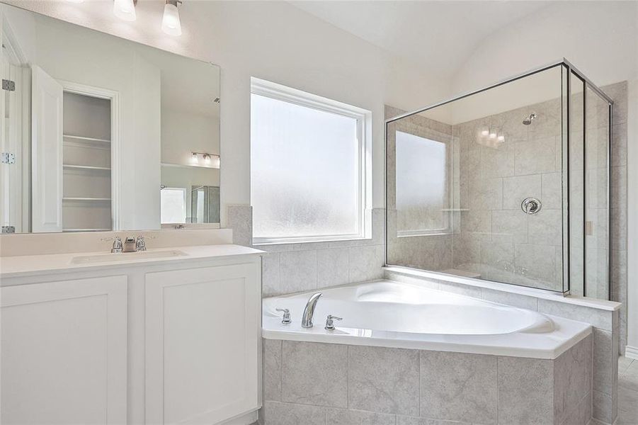 Bathroom with vanity, lofted ceiling, and separate shower and tub