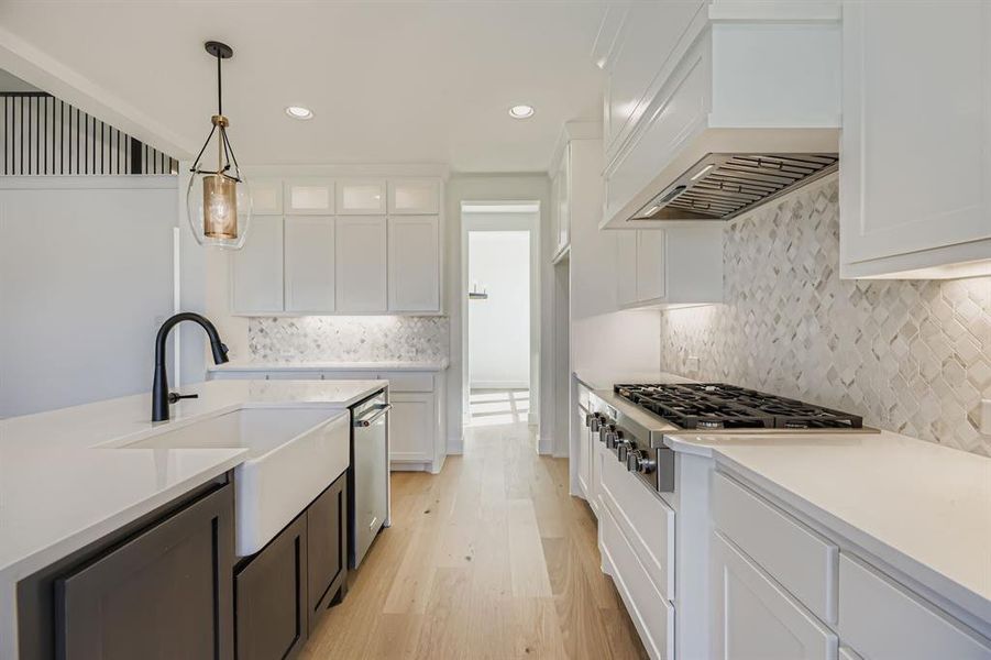 Kitchen with light wood-style flooring, white cabinetry, light countertops, recessed lighting, and appliances with stainless steel finishes