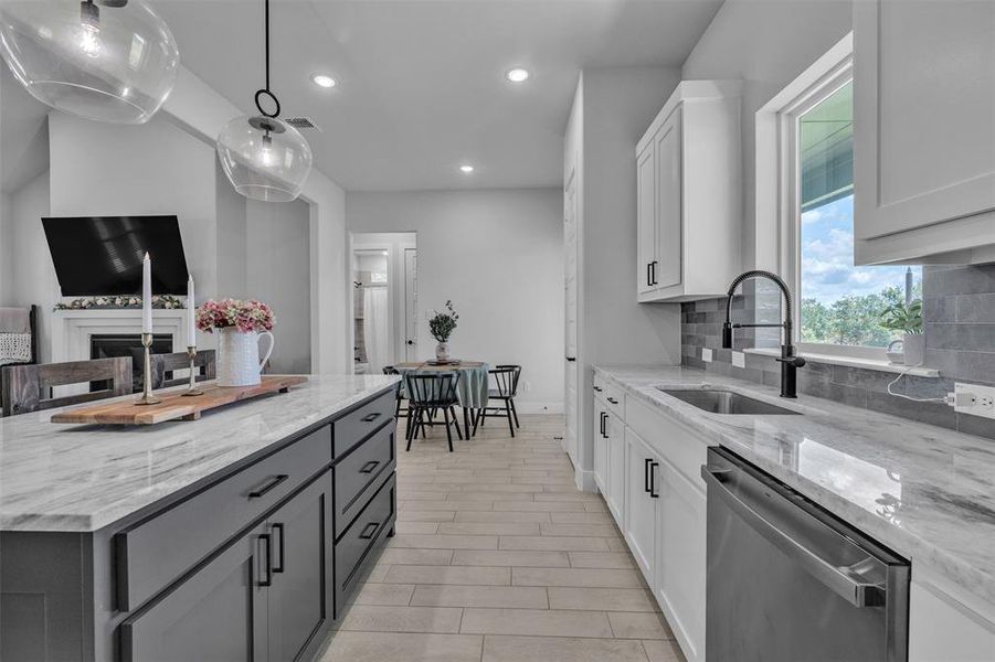Modern kitchen featuring a two-tone design with white perimeter cabinetry and a dark gray island