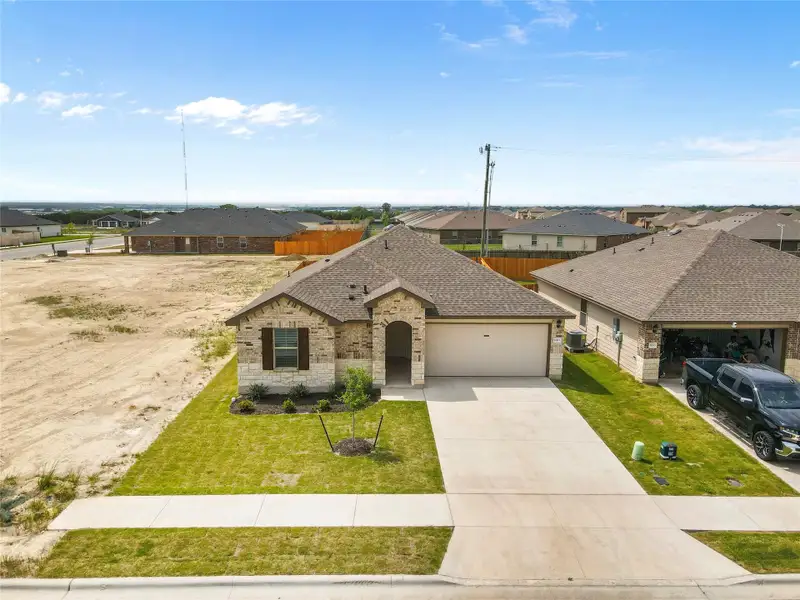 Front exterior of a new home in Reynolds Crossing, Killeen, TX, highlighting curb appeal (Image 1). Front exterior of a new home in Reynolds Crossing, Killeen, TX, highlighting curb appeal (Image 1).