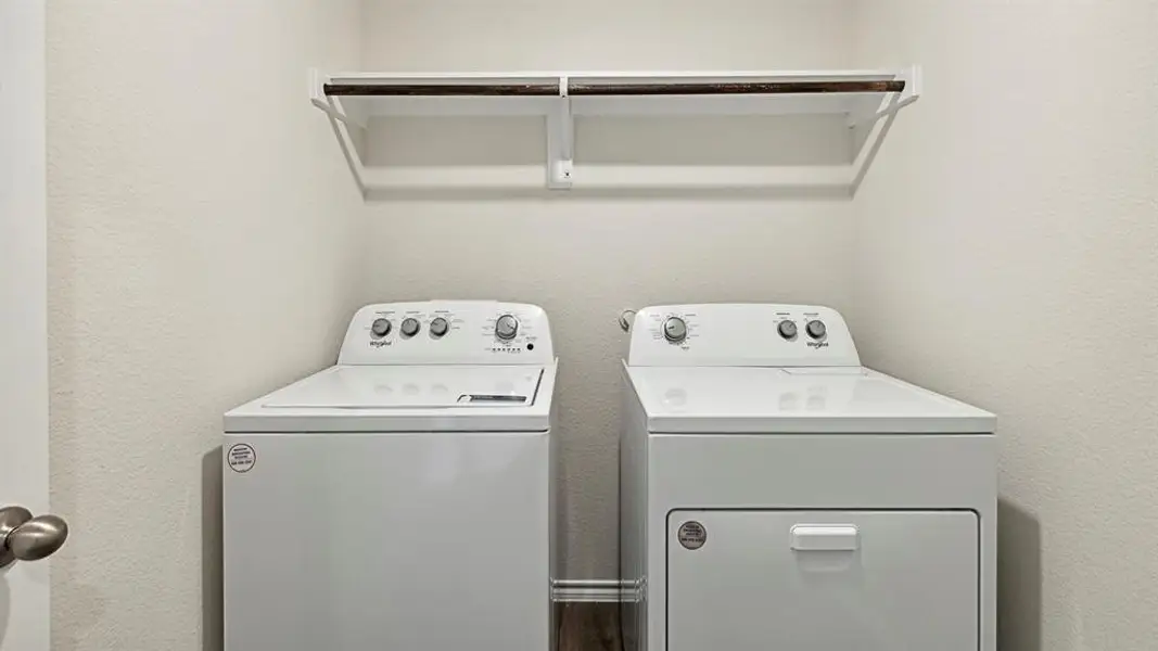 Laundry area featuring washing machine and dryer and a textured wall Laundry area featuring washing machine and dryer and a textured wall