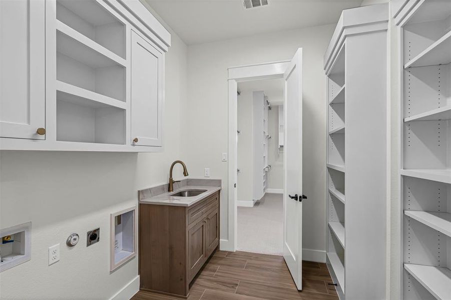 Laundry area featuring gas dryer hookup, wood tiled floors, cabinet space, and hookup for a washing machine Laundry area featuring gas dryer hookup, wood tiled floors, cabinet space, and hookup for a washing machine