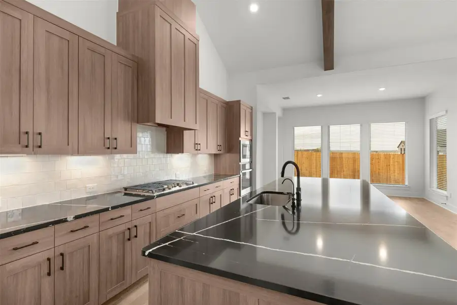 Kitchen with recessed lighting, beam ceiling, light brown cabinetry, decorative backsplash, and light wood-style flooring Kitchen with recessed lighting, beam ceiling, light brown cabinetry, decorative backsplash, and light wood-style flooring