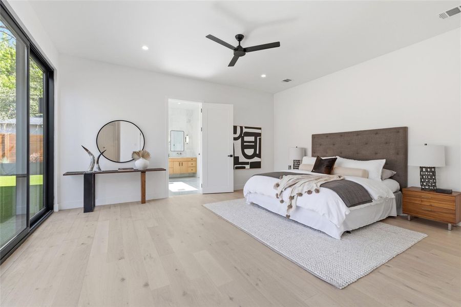 Bedroom featuring light wood-type flooring, ceiling fan, recessed lighting, connected bathroom, and access to exterior
