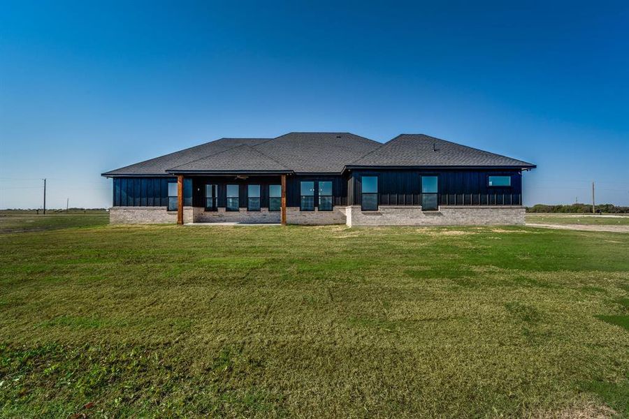 Rear view of property with a lawn