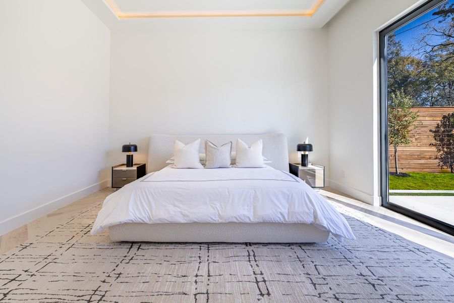 Primary bedroom with expansive windows and backyard views. Primary bedroom with expansive windows and backyard views.