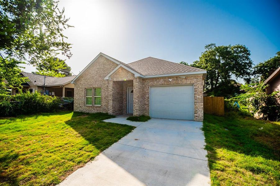 Ranch-style home featuring a garage and a front lawn