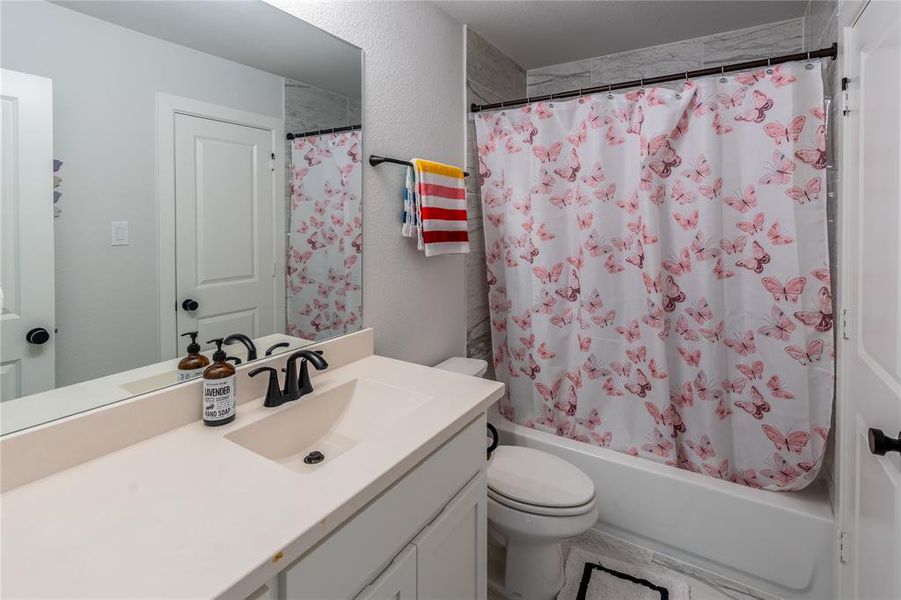 Full bath with double vanity and curtained shower