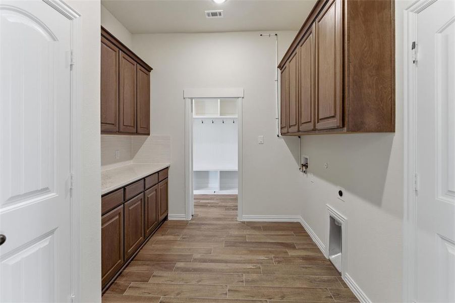 Laundry room with cabinet space, wood finish floors, hookup for an electric dryer, and hookup for a washing machine Laundry room with cabinet space, wood finish floors, hookup for an electric dryer, and hookup for a washing machine