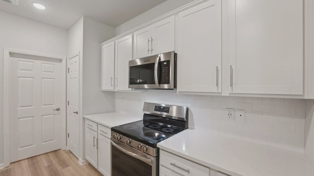 Elegant handcrafted cabinetry and sleek quartz create a sophisticated culinary space in Palm Coast's luxury home.
