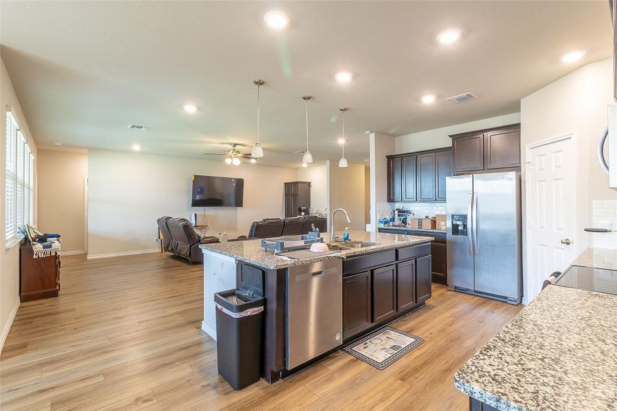 An open floorplan seamlessly connects the well-lit kitchen with the comfortable living space.