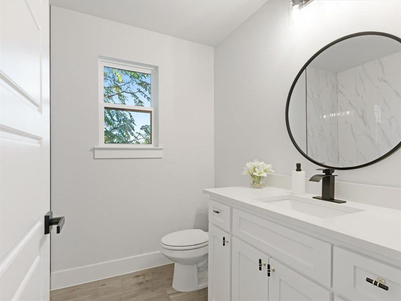 Bathroom with hardwood / wood-style floors, vanity, and toilet