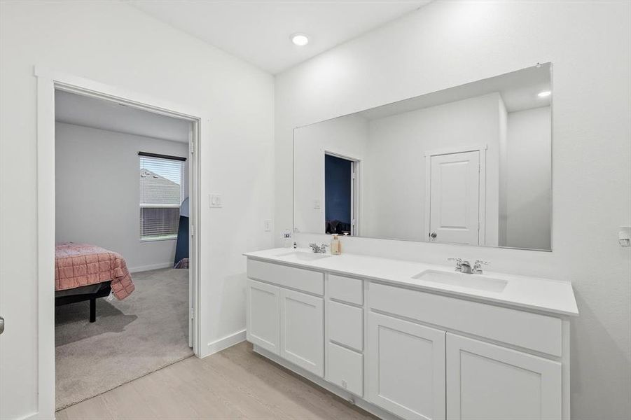 Dual vanity featuring two undermount sinks, chrome fixtures, and a white countertop Dual vanity featuring two undermount sinks, chrome fixtures, and a white countertop