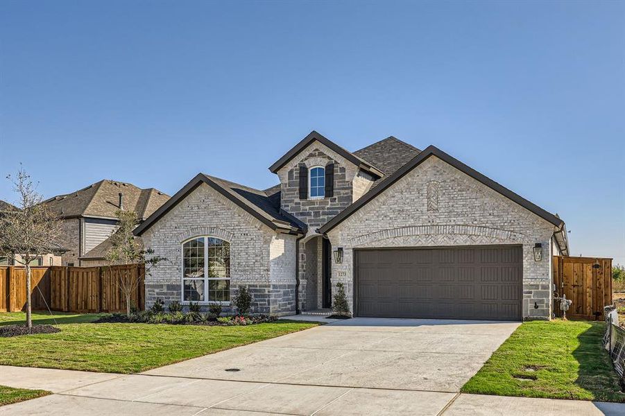 French country style house with a front yard and a garage