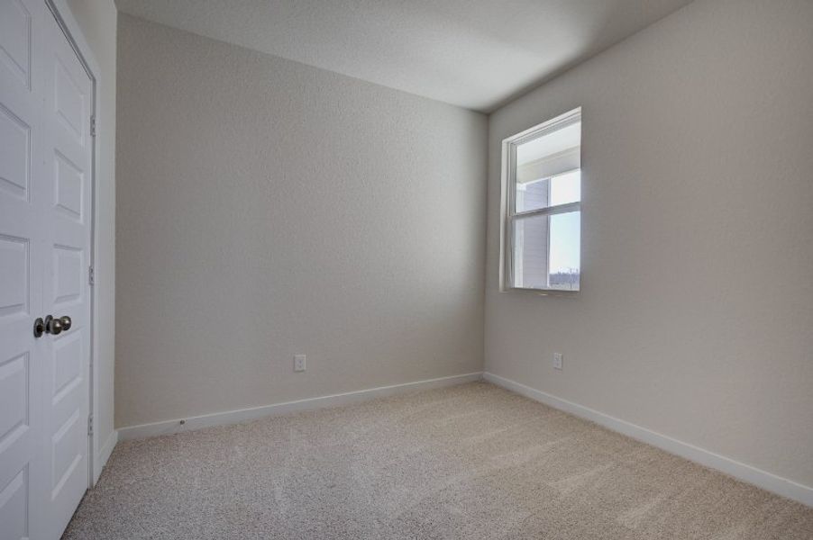A room with a window and a carpet.