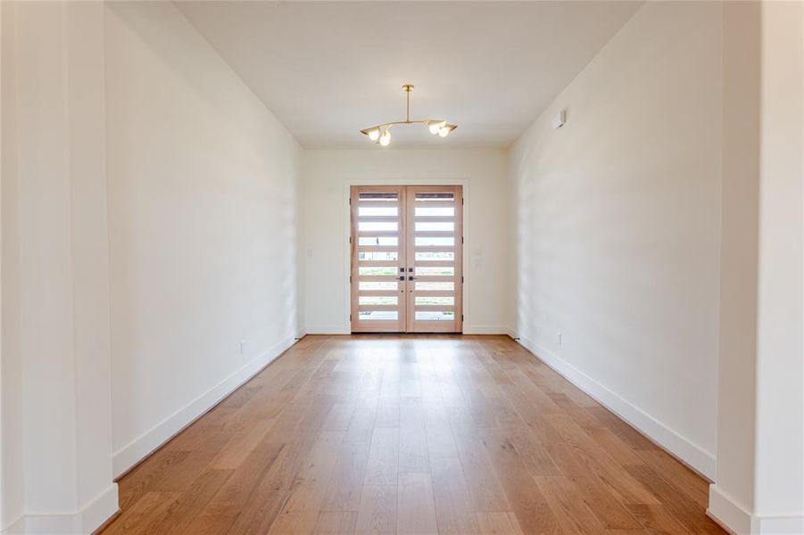 Unfurnished room featuring french doors and light wood-style flooring