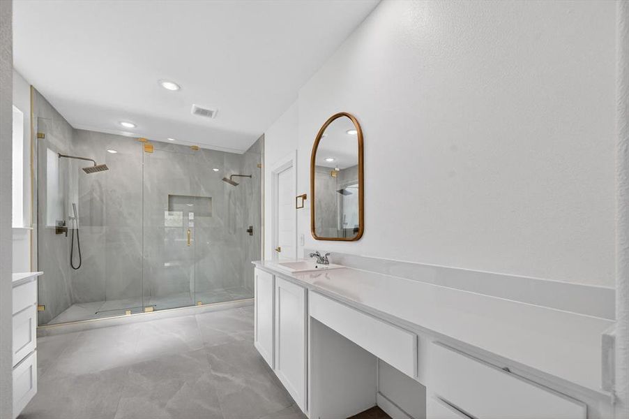 Spacious bathroom featuring a dual walk-in shower with grey-toned stone-look tile, glass enclosure, and multiple showerheads