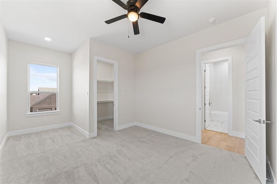 Unfurnished bedroom featuring a spacious closet, ceiling fan, light colored carpet, and recessed lighting Unfurnished bedroom featuring a spacious closet, ceiling fan, light colored carpet, and recessed lighting