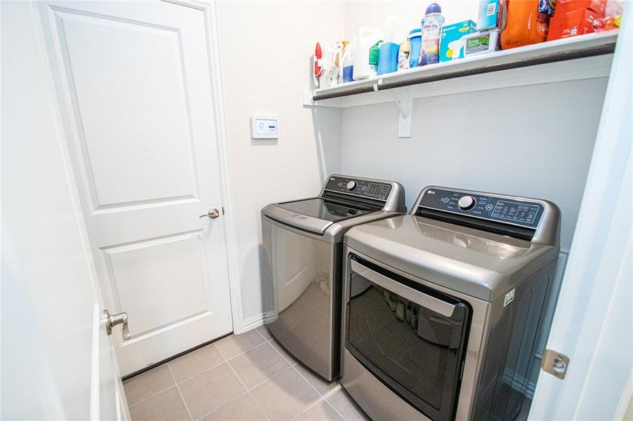 Laundry room with light tile patterned flooring and washing machine and clothes dryer Laundry room with light tile patterned flooring and washing machine and clothes dryer