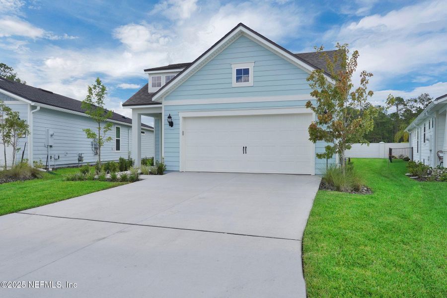 Front exterior of a new home in Summer Bay at Grand Oaks, St. Augustine, FL, highlighting curb appeal (Image 2). Front exterior of a new home in Summer Bay at Grand Oaks, St. Augustine, FL, highlighting curb appeal (Image 2).