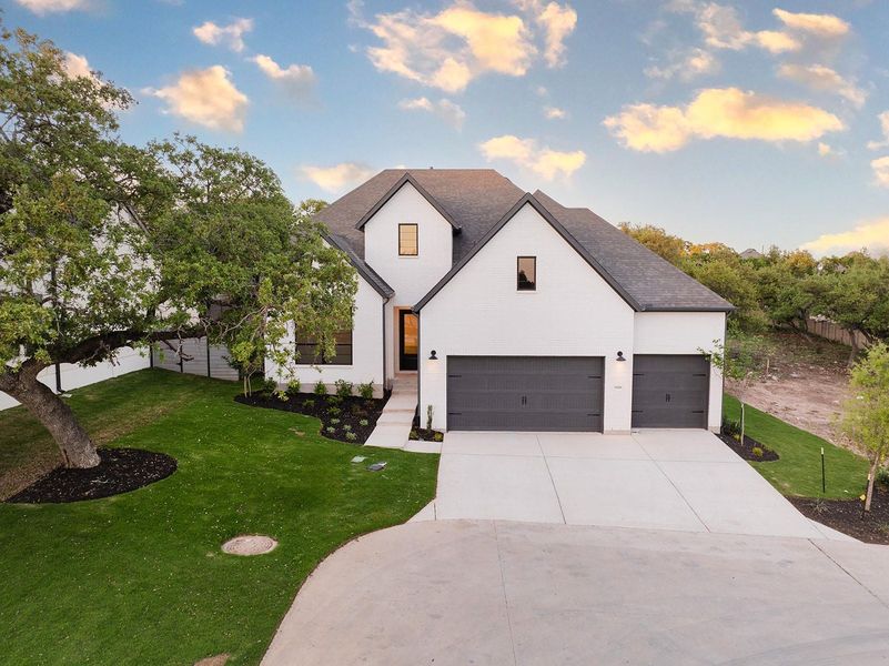 Modern inspired farmhouse featuring a front yard, concrete driveway, a shingled roof, and a garage Modern inspired farmhouse featuring a front yard, concrete driveway, a shingled roof, and a garage