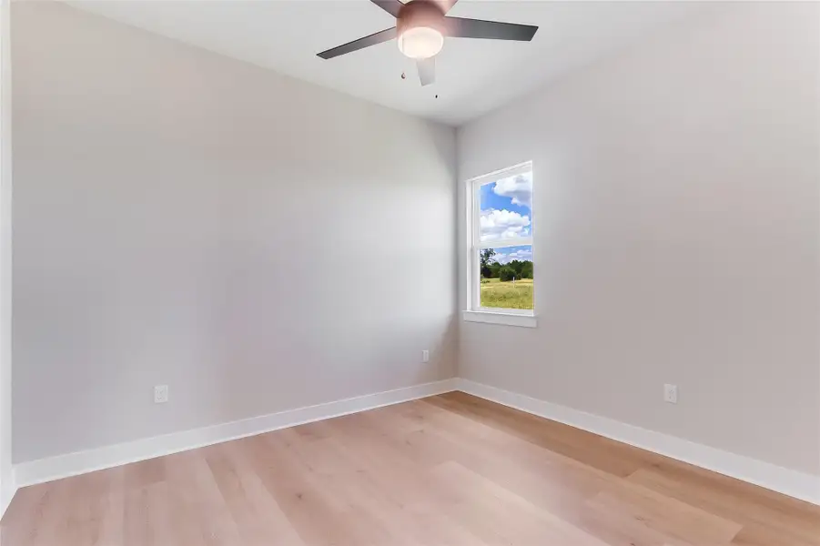 Empty room with light wood-type flooring and ceiling fan