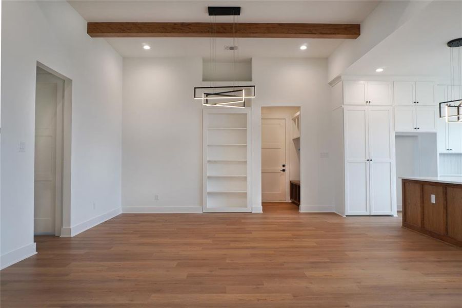 Unfurnished bedroom with light hardwood / wood-style floors and beam ceiling