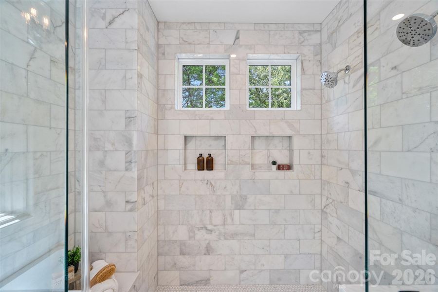 Oversized tile shower with bench and dual niches