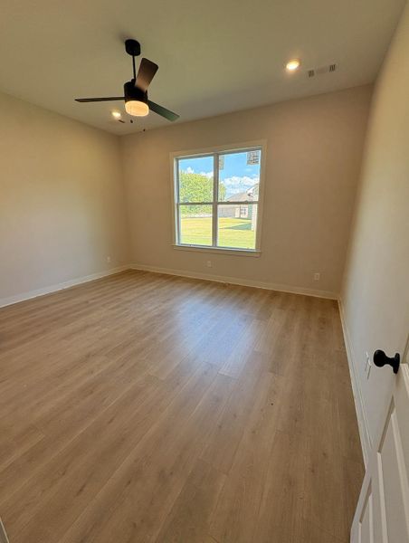 Wood-finish flooring, recessed lighting, ceiling fan with integrated light, and large window Wood-finish flooring, recessed lighting, ceiling fan with integrated light, and large window