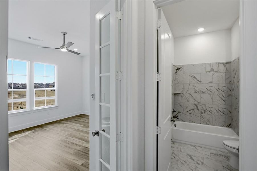 Full bath featuring shower / bath combination and ceiling fan