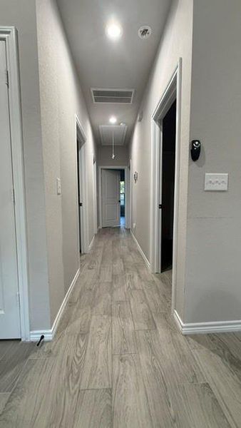 Hallway leading to all three bedrooms, utility room with door to backyard, and bathrooms.