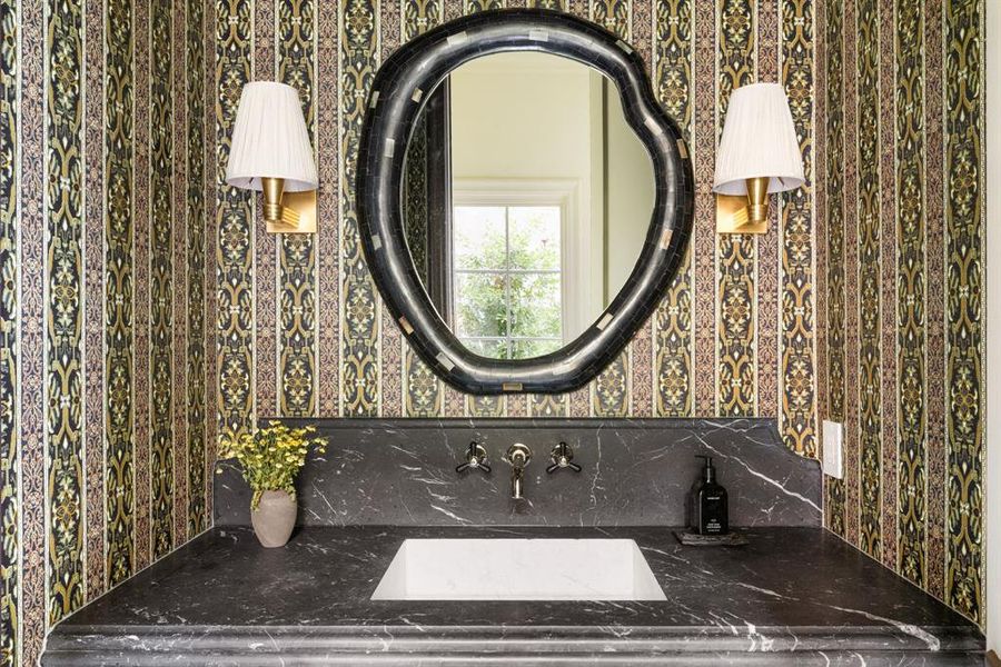 Bathroom with wallpapered walls and vanity Bathroom with wallpapered walls and vanity