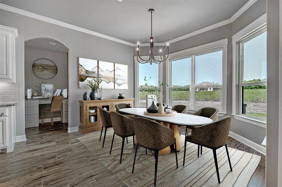 Dining area with wood-type flooring, an inviting chandelier, and crown molding