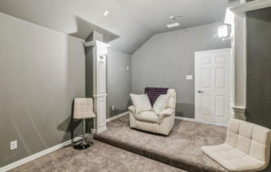 Living area with lofted ceiling and carpet floors