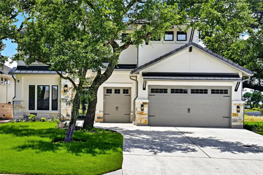 Elegant two-story residence showcasing multiple garage doors and a well-maintained, lush front lawn. Elegant two-story residence showcasing multiple garage doors and a well-maintained, lush front lawn.