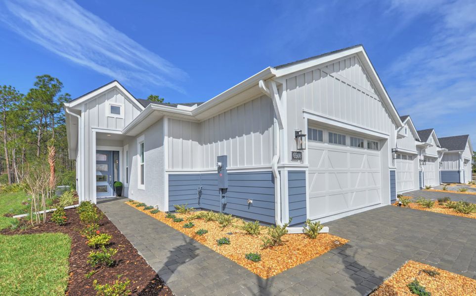 Front exterior of a new home in Woodhaven, Port Orange, FL, highlighting curb appeal (Image 2). Front exterior of a new home in Woodhaven, Port Orange, FL, highlighting curb appeal (Image 2).